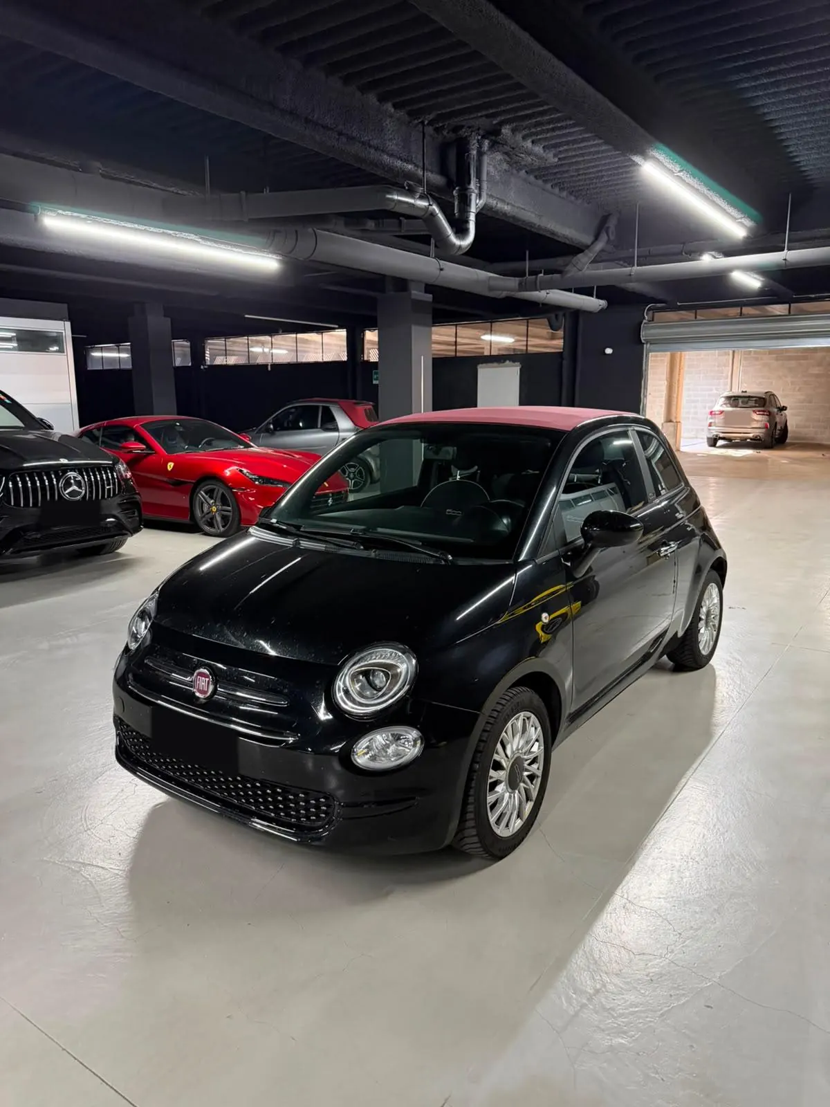 Fiat 500 Cabrio nera con capote bordeaux, vista di tre quarti dal davanti