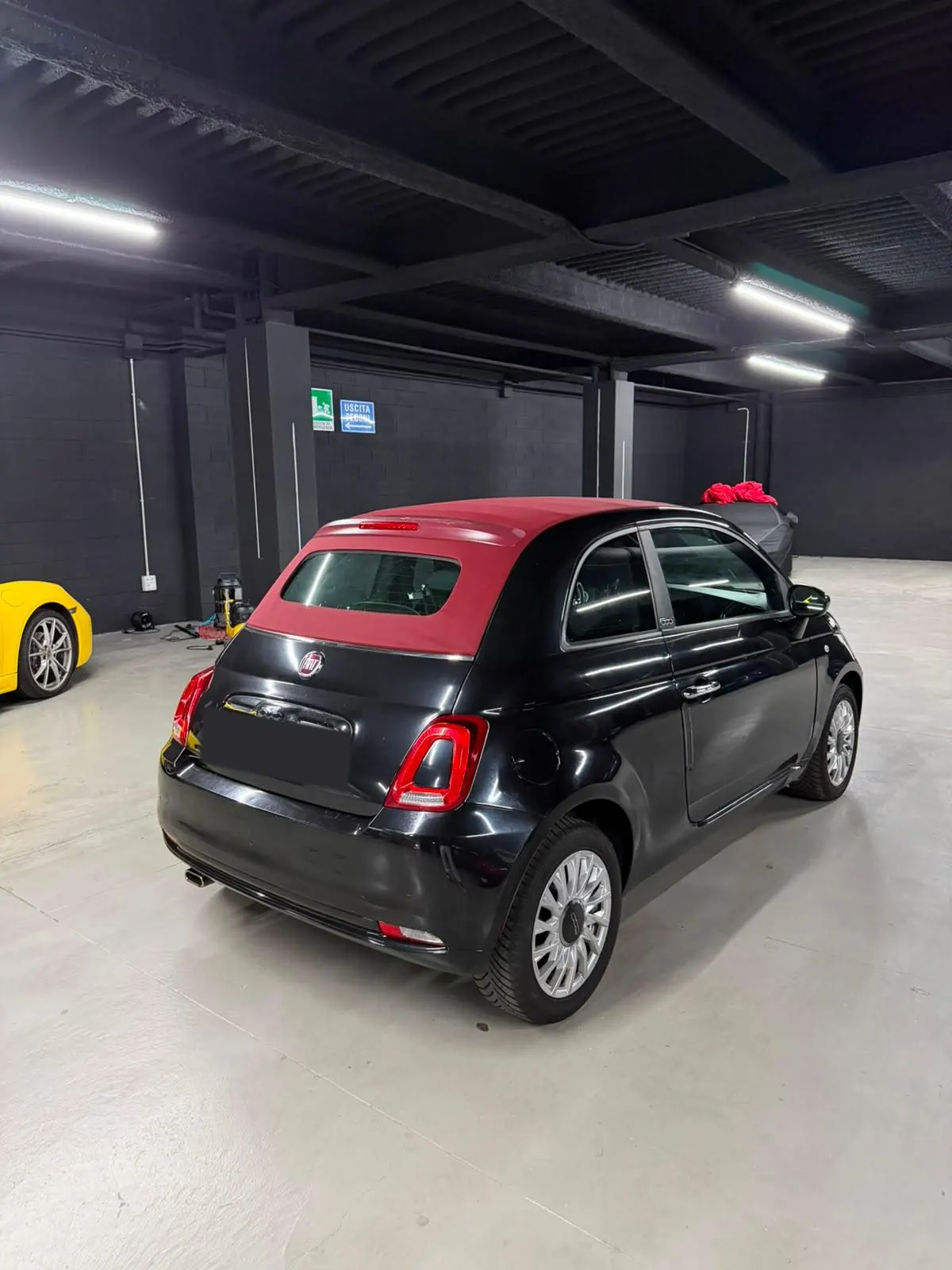 Fiat 500 Cabrio nera vista da dietro, con la capote bordeaux chiusa